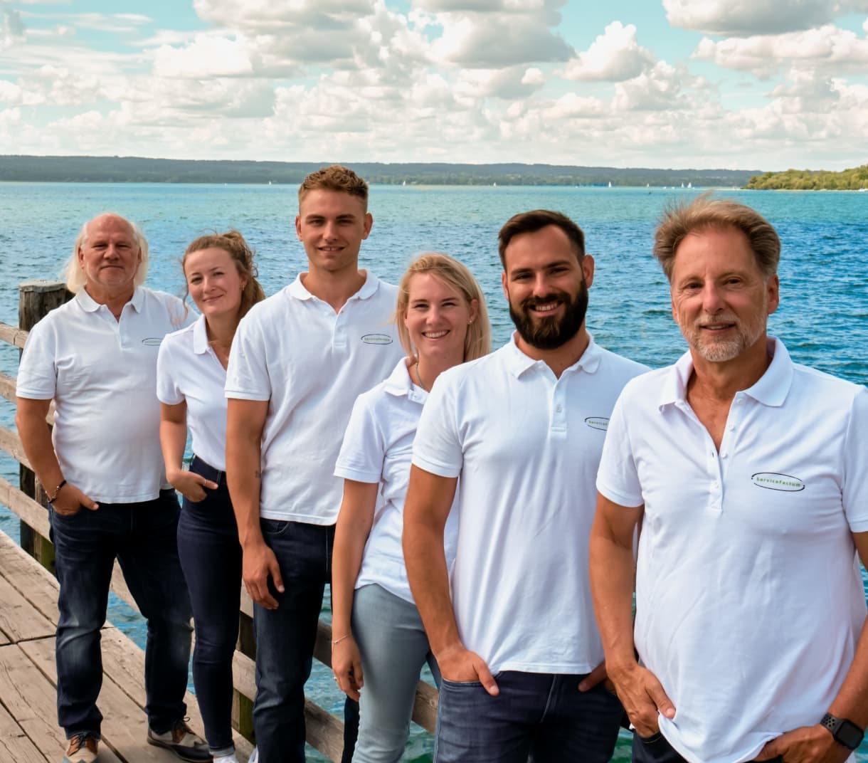 Das Team von ServiceFactum am blauen See in Herrsching in weißen Firmenshirts