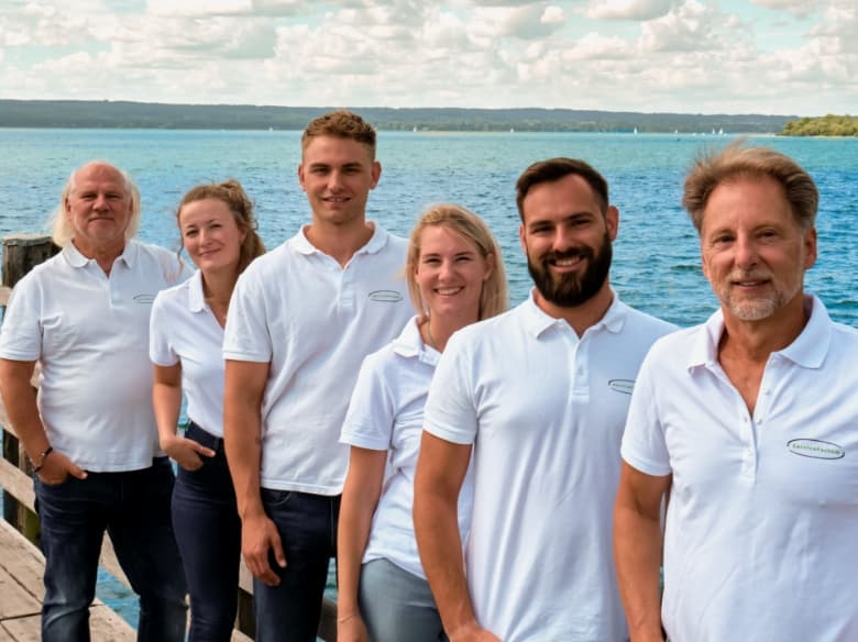 Das Team von ServiceFactum am blauen See in Herrsching in weißen Firmenshirts