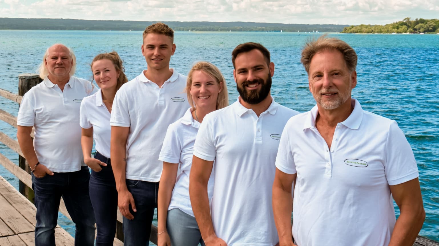 Das Team von ServiceFactum am blauen See in Herrsching in weißen Firmenshirts
