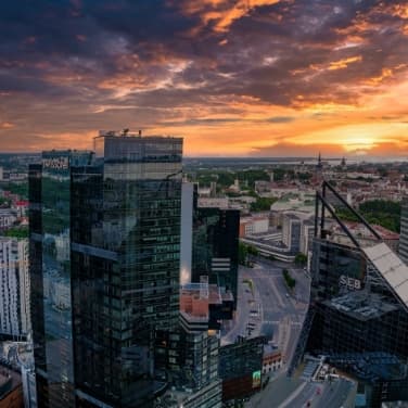 Sonnenuntergang in einer Stadt in Estland mit Glas-Hochhäusern im Vordergrund.